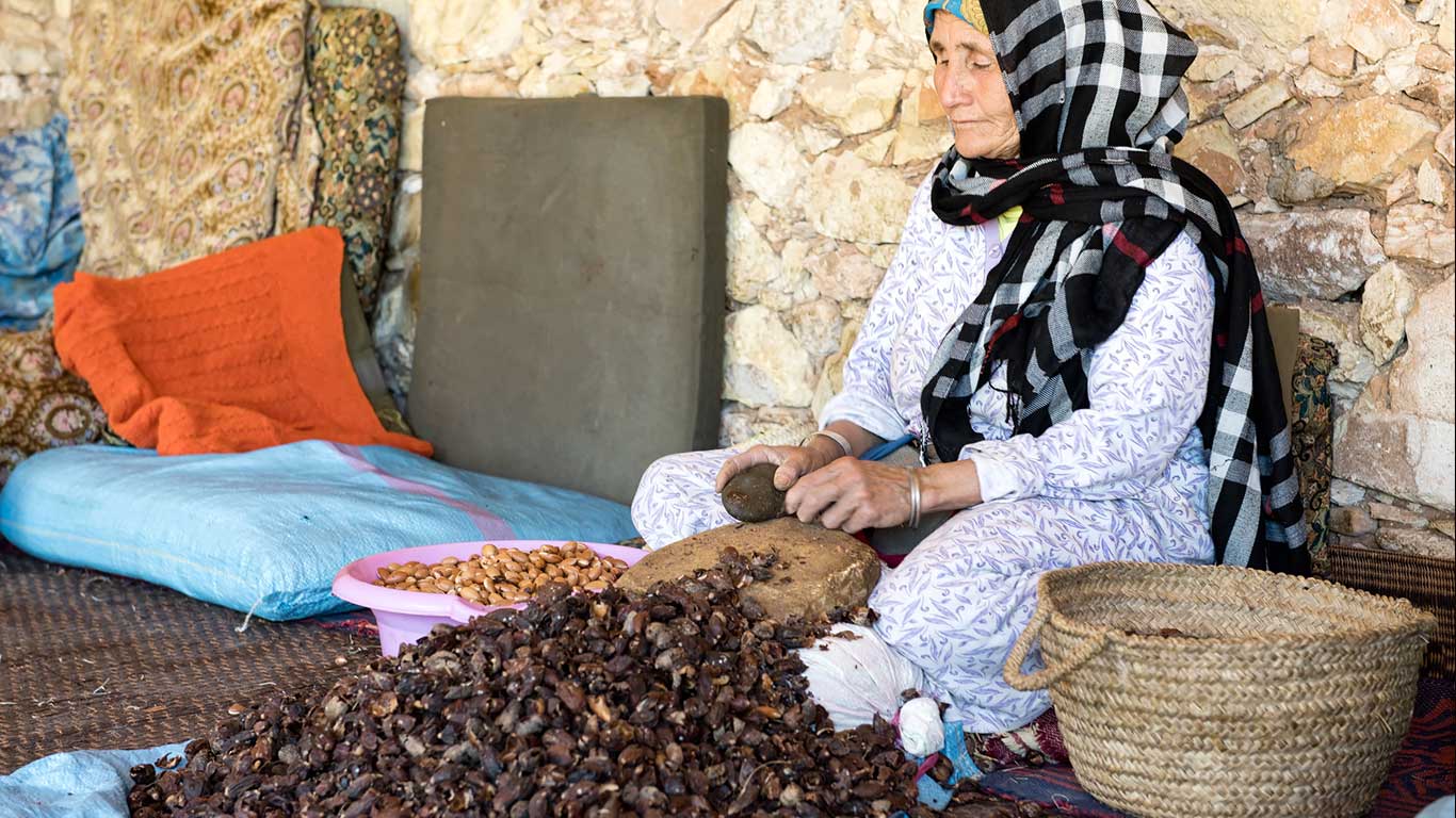 donna anziana estrae olio di argan